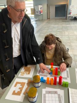 Gilles Dowek et Michèle Artigue sont très concentrés sur un plateau de jeu de gratte-ciel
